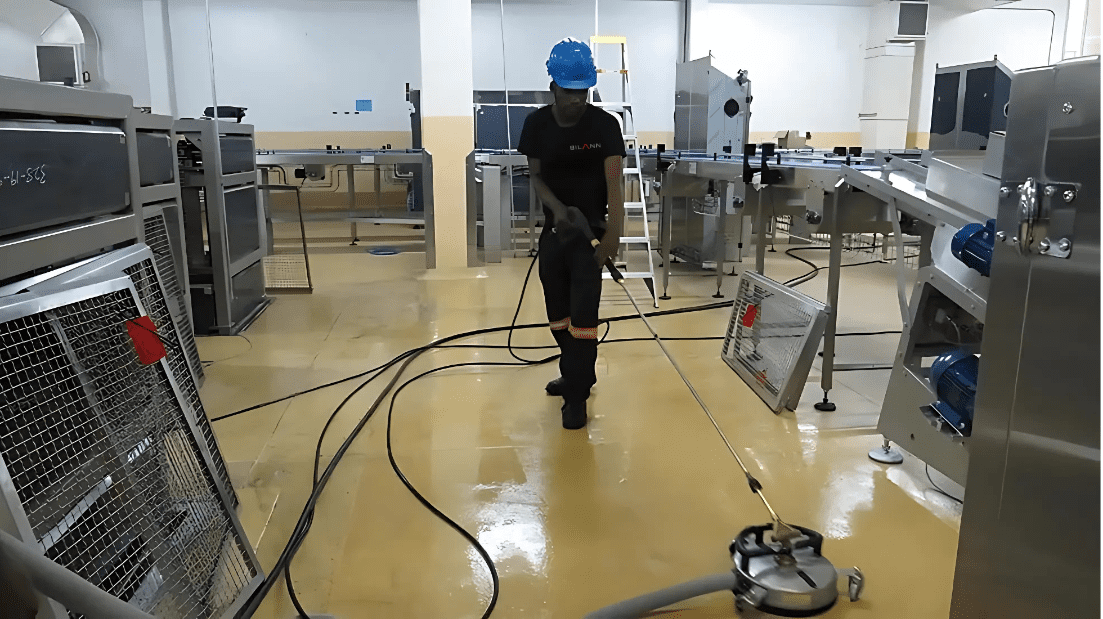 Professional cleaner performing industrial floor cleaning in a warehouse facility for safety and maintenance