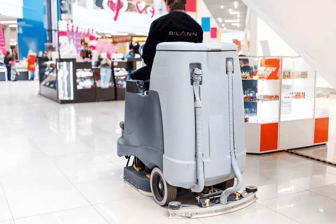 Professional cleaner vacuuming the floor inside a retail store to maintain cleanliness and hygiene